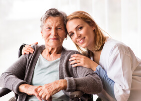 caregiver and elder woman smiling
